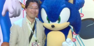 Yuji Naka posing with Sonic mascot