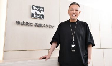 Toshihiro Nagoshi against the logo of Nagoshi Studio