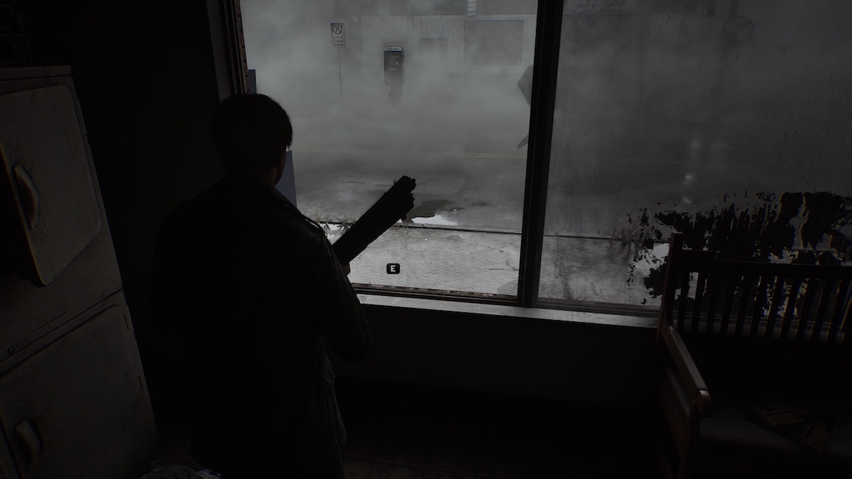 James inside a dark room in Silent Hill 2 remake. The street outside is full of fog